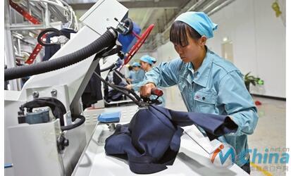 10月8日，工人正在智能化服装生产线上操作设备